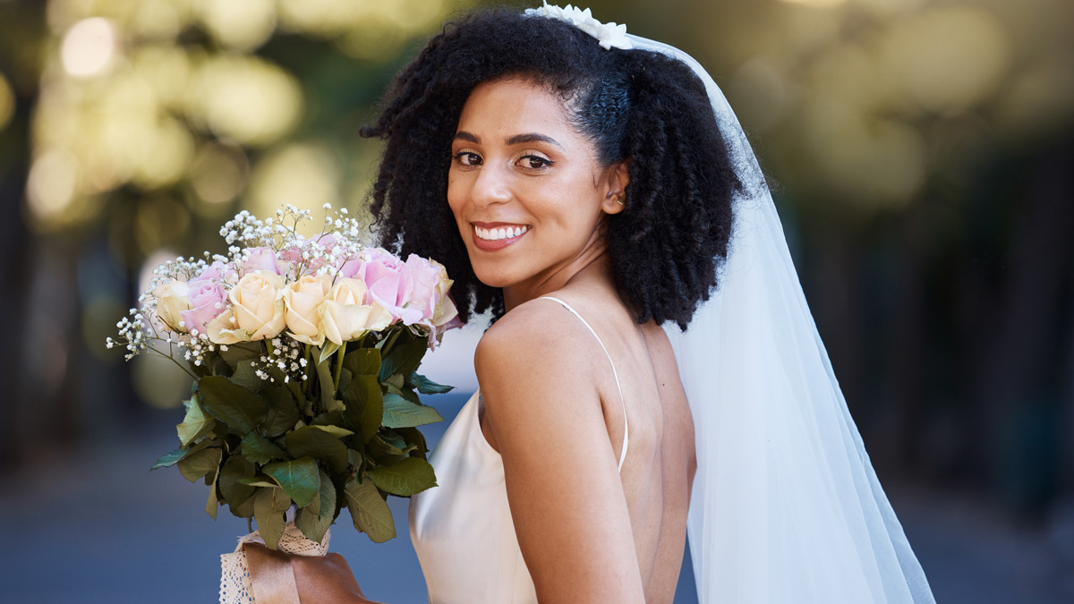 Beautiful Black bride showcasing a stunning natural hair updo for her wedding day.