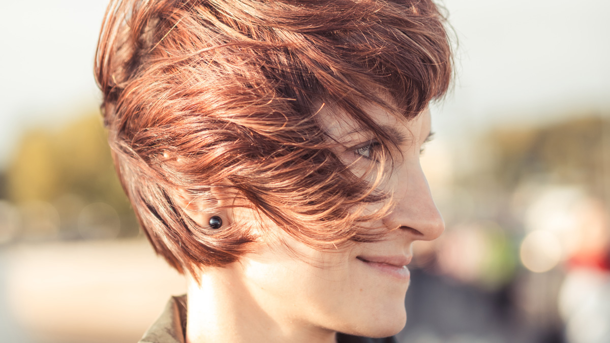 Fashionable woman modeling a chic short hairstyle with refined texture and luxury shine.