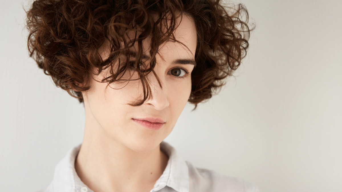 Beautiful woman highlighting a bouncy short hairstyle with perfectly hydrated cropped curls.
