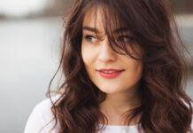 Curtain Bangs: The Ultimate Hair Trend You Need to Try Beautiful portrait of a woman with long hair and soft face-framing curtain bangs.