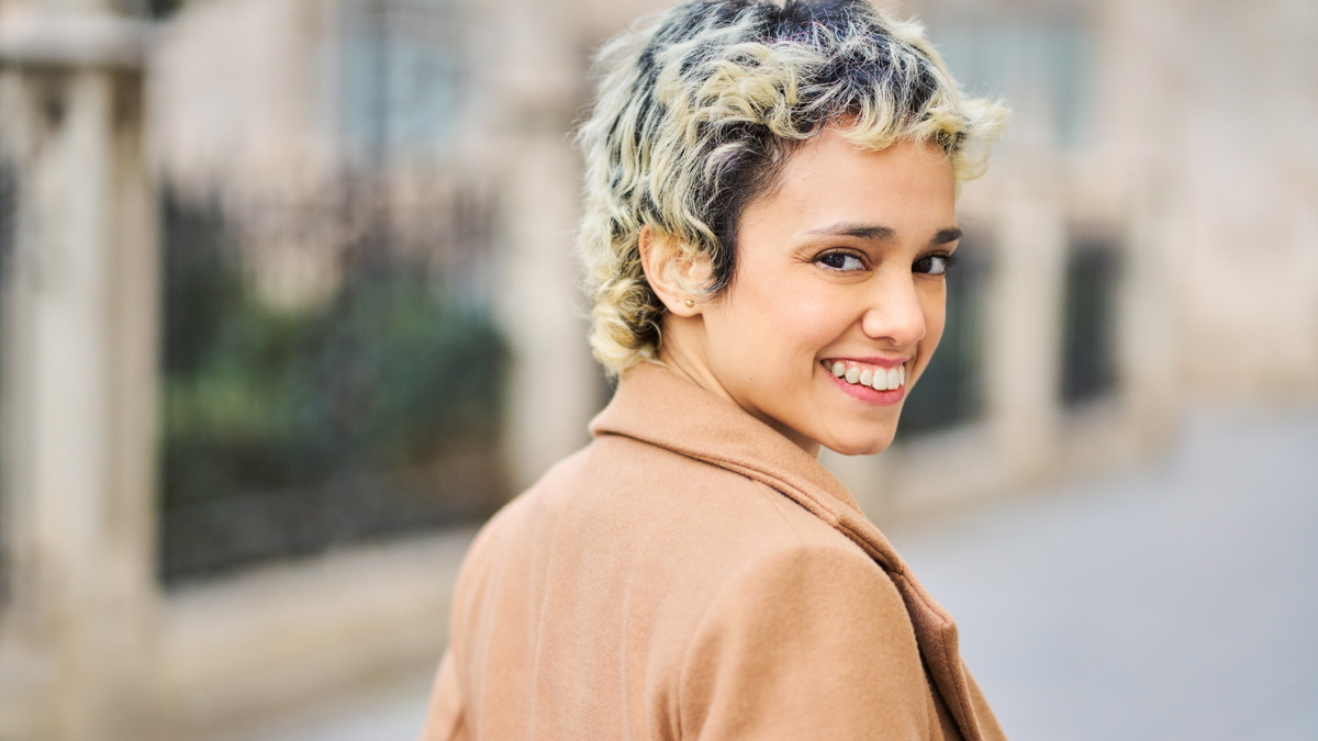 Confident female model with a highly textured and modern short pixie cut hairstyle.