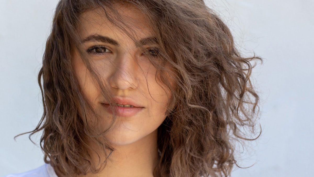 Woman with a perfectly styled modern shaggy haircut full of volume and face-framing fringe.