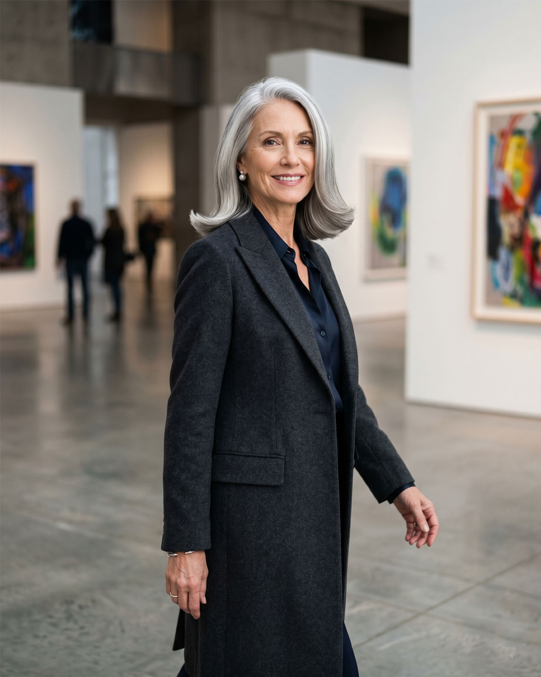 A beautiful mature woman indoors with a smooth, contoured silver mid-length cut.