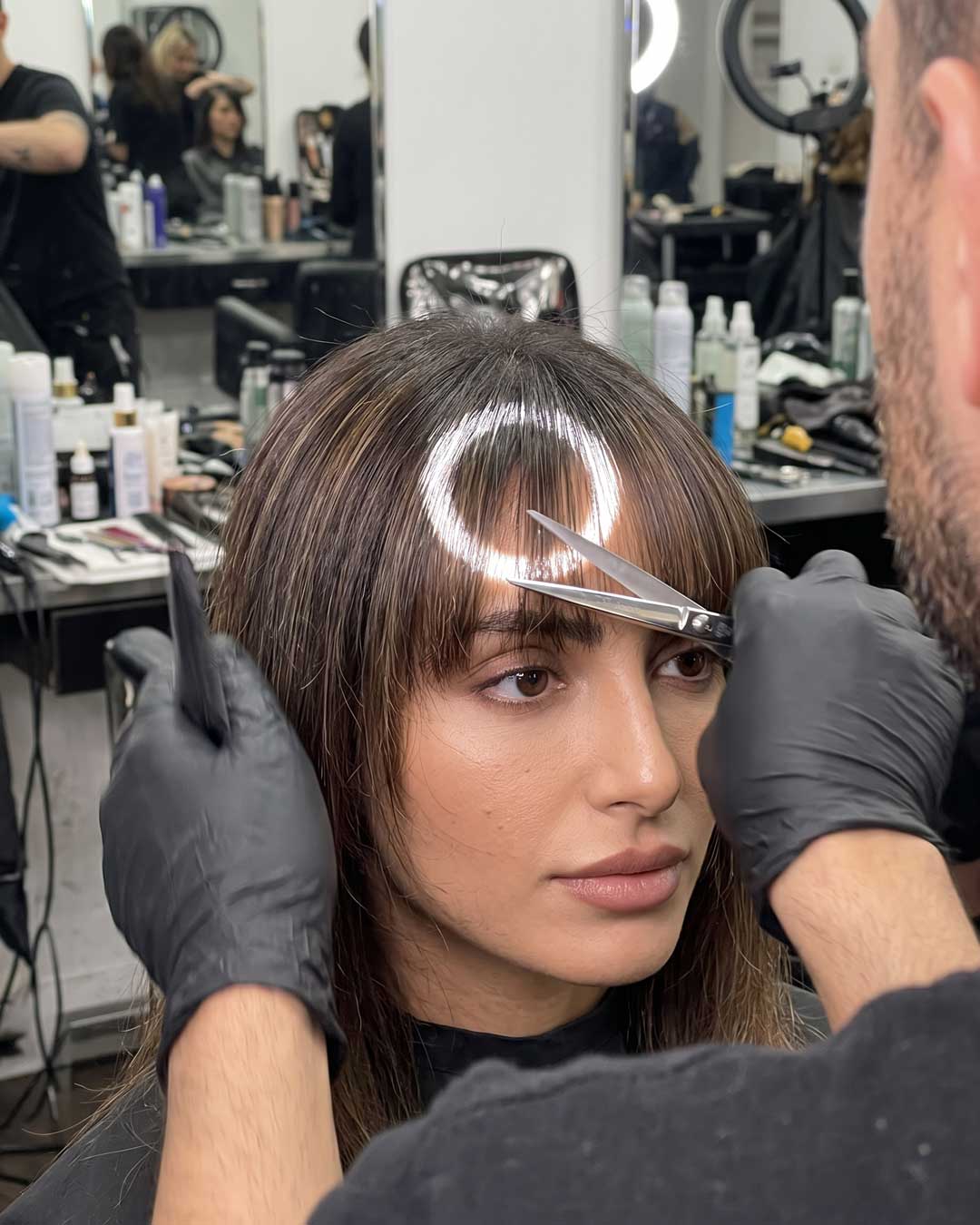 Stylist executing the point cutting technique on the delicate fringe